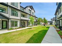 Modern two-story townhouse featuring a well-manicured lawn and a sidewalk leading to the entrance at 8530 W 52Nd Ave # A1, Arvada, CO 80002