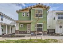 Charming two-story home with green siding, large windows, and well-manicured lawn at 910 Promenade Dr, Superior, CO 80027