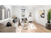 Bright living room boasts stylish decor, natural light, and hardwood floors, perfect for relaxing or entertaining at 3231 S Estes St, Lakewood, CO 80227