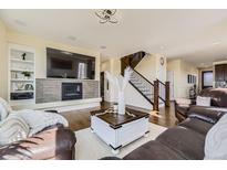 Cozy living room with fireplace, built-in shelving, and hardwood floors at 12291 Coral Burst Ct, Parker, CO 80134
