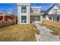 Modern two-story home with stone accents, balcony, xeriscaped front yard, and concrete steps at 2409 W 38Th Ave, Denver, CO 80211