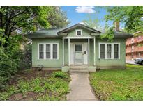 Charming one-story home with green siding, covered entry, and walkway leading to the front door at 1900 S University Blvd, Denver, CO 80210