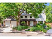 Charming two-story home with landscaped yard and large shade tree covering the home at 7873 E Colgate Pl, Denver, CO 80231