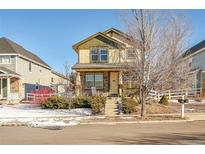 Charming two-story home features a cozy front porch and stone accents, complemented by a well-maintained yard at 1172 S Coolidge Cir, Aurora, CO 80018