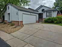 Charming home exterior features a two-car garage, concrete driveway, and tidy landscaping at 11196 E Baltic Dr, Aurora, CO 80014