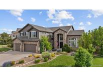 Beautiful two-story home with stone and siding, complemented by a well-manicured lawn and landscaping at 7408 Sodalite Way, Castle Rock, CO 80108