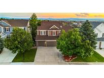 Two-story home with a well-manicured lawn, mature trees, and a driveway leading to a two-car garage at 23060 Hope Dale Ave, Parker, CO 80138