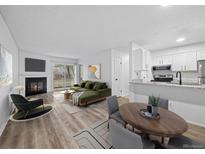 Bright living room features a fireplace, wood floors, and a sliding glass door to a balcony at 14720 E Kentucky Dr # 612, Aurora, CO 80012