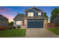 Charming two-story home featuring a blue exterior, brick accents, and a well-maintained front yard at 5124 S Jebel St, Centennial, CO 80015