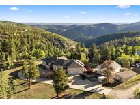 Stunning mountain home with a circular driveway and views of the surrounding green landscape at 12291 S Critchell Ln, Littleton, CO 80127