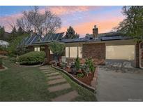 Brick home with solar panels, landscaped yard, and flagstone walkway leading to the front door at dusk at 805 Union Ave, Boulder, CO 80304