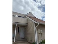 Charming home featuring light beige siding, a brown roof, and a cozy front porch entry at 2491 S Xanadu Way # A, Aurora, CO 80014