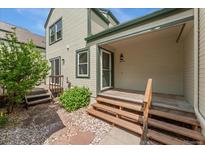 Charming covered front porch with wooden steps and light green siding enhances the home's curb appeal at 6414 S Hudson St, Centennial, CO 80121
