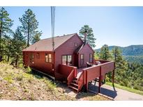 Charming mountain home with a spacious deck offering serene views of the surrounding landscape at 7350 Timber Trail Rd, Evergreen, CO 80439