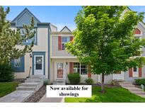 Charming townhome featuring a well-maintained lawn, colorful shutters, and mature trees at 9278 W Ontario Dr, Littleton, CO 80128