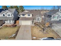 Two-story house with attached garage and landscaping at 12047 W Coal Mine Dr, Littleton, CO 80127