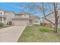 Charming two-story home with landscaped yard, attached two-car garage, and inviting curb appeal at 12047 W Coal Mine Dr, Littleton, CO 80127