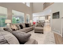 Bright living room with soaring ceilings, neutral paint, large windows and view of the kitchen at 24686 E Florida Ave, Aurora, CO 80018