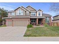 Charming two-story home with a well-manicured lawn and attached two car garage at 11615 E Maplewood Ave, Englewood, CO 80111