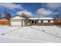 Charming single-story home featuring a two-car garage and snow-covered front lawn under a partly cloudy sky at 11644 Jackson St, Thornton, CO 80233