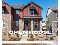 Two-story home with stone and red siding, welcoming front porch, and landscaping at 8115 Mt Harvard Rd, Littleton, CO 80125