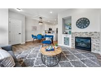 Bright living room featuring a fireplace with stone accents, hardwood floors, and stylish furnishings at 5555 E Briarwood Ave # 2604, Centennial, CO 80122