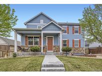 Charming two-story blue home with a welcoming front porch and meticulously maintained lawn at 277 Jewel St, Brighton, CO 80603
