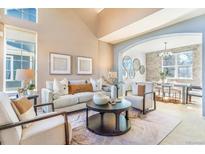 Bright, modern living room with stylish decor, neutral tones, and an open layout to the dining area at 10935 Acadia, Parker, CO 80138