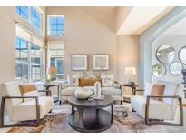 Bright and airy living room features large windows, neutral colors, and stylish furniture at 10935 Acadia, Parker, CO 80138