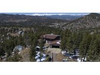 Beautiful exterior shot featuring a home with a dome structure surrounded by lush green trees and mountains at 29657 Loomis Way, Golden, CO 80403