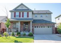 Charming two-story home with a brick and siding exterior, covered porch, and attached two-car garage at 24661 E Layton Pl, Aurora, CO 80016