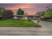Charming ranch home features a manicured lawn, lovely landscaping, and a two-car garage at 6427 S Ingalls St, Littleton, CO 80123