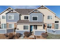 Charming two-story townhouse with blue accents, a covered front porch and landscaped yard, creating a welcoming curb appeal at 15800 E 121St Ave # 5F, Brighton, CO 80603