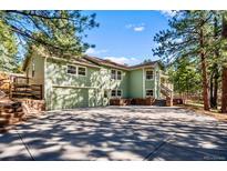 Charming two-story home with a spacious driveway and a lush green lawn, complemented by a two-car garage at 4185 Red Rock Dr, Larkspur, CO 80118