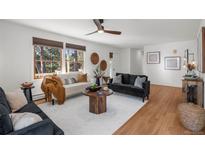 Inviting living room with hardwood floors, neutral paint, ceiling fan, and stylish decor at 4185 Red Rock Dr, Larkspur, CO 80118