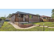 Charming brick home with a covered front porch and well-maintained landscaping at 925 Wolff St, Denver, CO 80204
