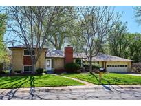 Charming brick home with a well-maintained lawn and mature trees creating an inviting curb appeal at 2330 Yarrow St, Lakewood, CO 80214