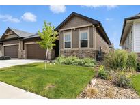 Charming exterior of home with a well-manicured lawn, stone accents and tidy landscape at 6712 Sea Oats Dr, Parker, CO 80138