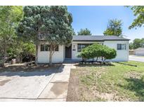 Charming single-story home with white siding, complemented by mature trees and a well-maintained lawn at 1900 Kingston St, Aurora, CO 80010