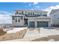 Two story home boasts stone accents, gray siding, and a two-car garage at 4996 Hickory Oaks St, Castle Rock, CO 80104