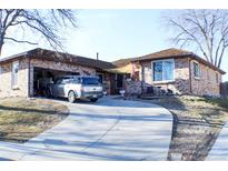 Charming single-story brick home with an attached garage, curved driveway and well-maintained lawn at 271 S Salem Ct, Aurora, CO 80012