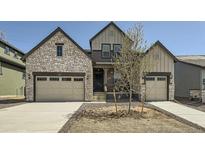Inviting home featuring a stone facade, tandem three-car garage, and contemporary architectural details at 2924 S Poppy St, Morrison, CO 80465