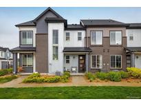 Modern townhome showcasing stylish architecture, a well-manicured lawn, and inviting front porch seating at 9305 S Gore St # C, Arvada, CO 80007