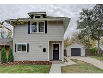 Charming two-story home featuring a detached garage and well-maintained front yard and black shutters at 4142 Chase St, Denver, CO 80212