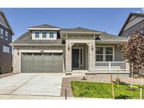 Charming exterior view of a stone-accented two-story home with a well-manicured lawn and neutral colors at 576 Nightsky St, Erie, CO 80516