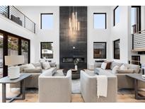 Bright and airy living room boasts a modern fireplace, soaring ceilings, and ample seating for entertaining at 1544 S Fillmore St, Denver, CO 80210