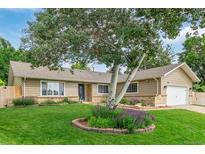 Charming single-story home with a well-manicured lawn, mature trees, and inviting curb appeal at 7719 S Jackson Cir, Centennial, CO 80122