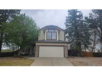 Charming two-story home with stone accents, lush trees, and an attached two-car garage at 18531 E Tanforan Pl, Aurora, CO 80015
