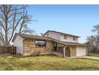 Charming two-story home with brick facade, well-maintained lawn, and attached two car garage on a sunny day at 789 Hamal Dr, Lone Tree, CO 80124