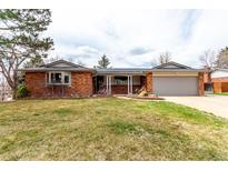 Charming one-story brick home with a well-manicured lawn and an attached two-car garage at 699 S Oswego St, Aurora, CO 80012
